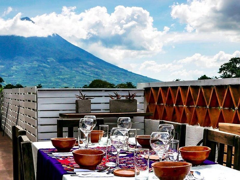 A breakfast table laid on a terrace below Volc&aacute;n de Agua